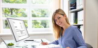 Uśmiechnięta kobieta przygotowuje e-fakturę KSeF