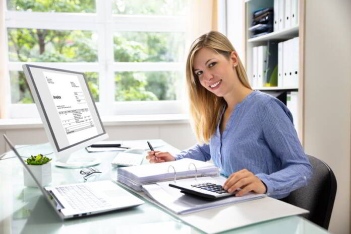 Uśmiechnięta kobieta przygotowuje e-fakturę KSeF
